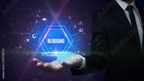 Wallpaper Mural Man hand holding BLOGGING inscription, social media concept Torontodigital.ca