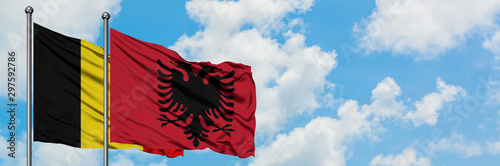 Belgium and Albania flag waving in the wind against white cloudy blue sky together. Diplomacy concept, international relations.