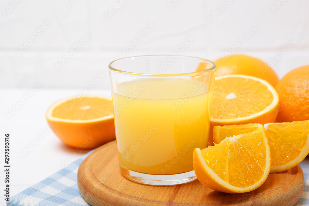 Orange juice in a glass, oranges and orange slices on the table. Orange juice in a glass, oranges and orange slices on the table.