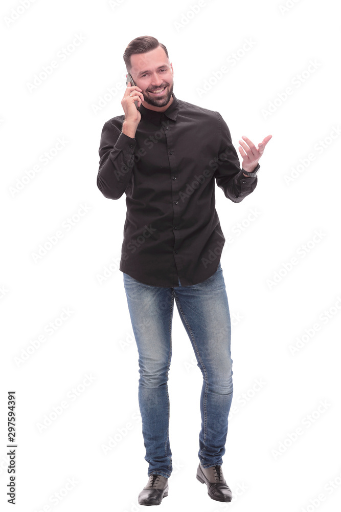 Fototapeta premium in full growth. smiling young man talking on his smartphone
