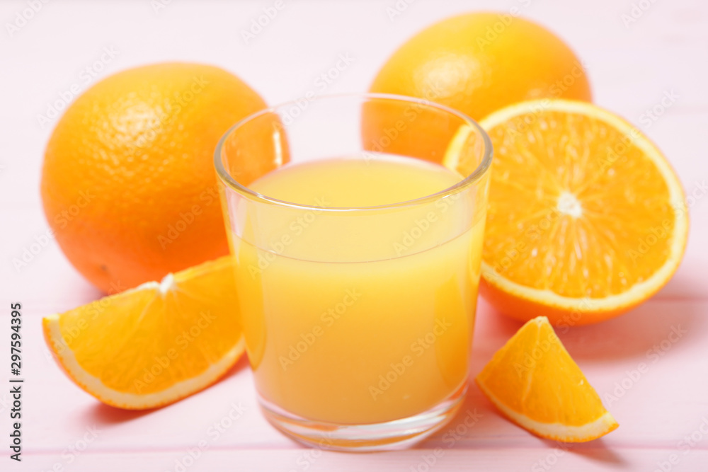 Orange juice in a glass, oranges and orange slices on the table. Orange juice in a glass, oranges and orange slices on the table.