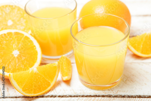 Orange juice in a glass, oranges and orange slices on the table.
