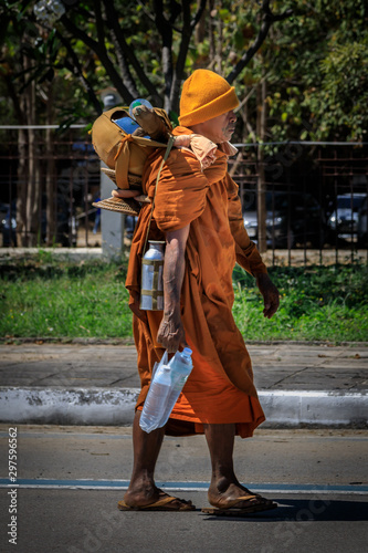 Wandermönch orange gekleidet geht auf einer Straße in Thailand © Frozen Action