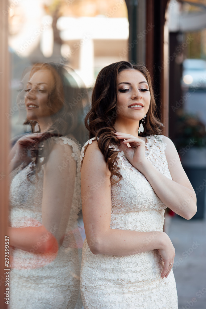 Fototapeta premium Beautiful woman with professional make up and hairstyle. Beautiful long curly hair woman with closed makeup eyes and manicured nails. Sexy girl posing. Female fashion.