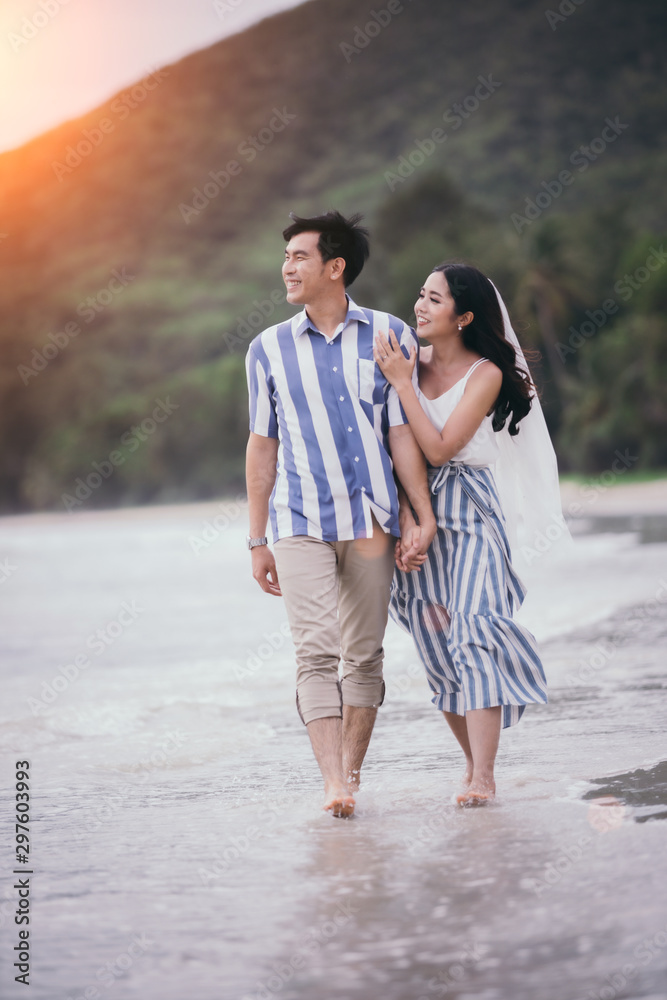 Valentines Day, Couple held their hands and walked smoothly on the seashore watching the sunset happily. Valentines Day, Couple held their hands and walked smoothly on the seashore watching the sunset happily.