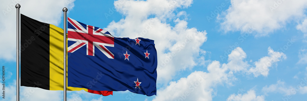 Belgium and New Zealand flag waving in the wind against white cloudy blue sky together. Diplomacy concept, international relations. Belgium and New Zealand flag waving in the wind against white cloudy blue sky together. Diplomacy concept, international relations.