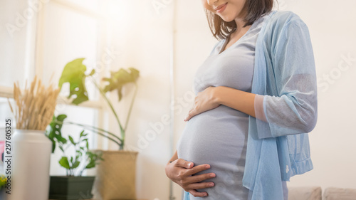 close up beauty happy Asian pregnant woman with big belly by window - pregnancy, motherhood, people and expectation concept.