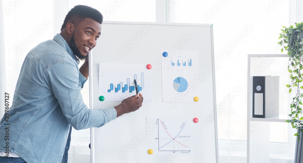 Confident african american guy presenting new business project in office Confident african american guy presenting new business project in office