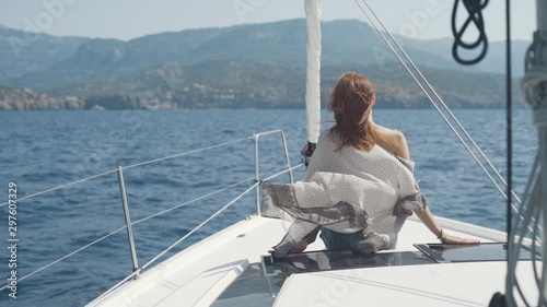 Beautiful woman on a yacht enjoys the journey on the background of the islands of Ibiza or Mallorca. Luxury yacht near the balearic islands