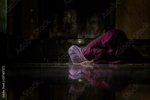 Muslim women wearing purple shirts Doing prayer According to the principles of Islam..