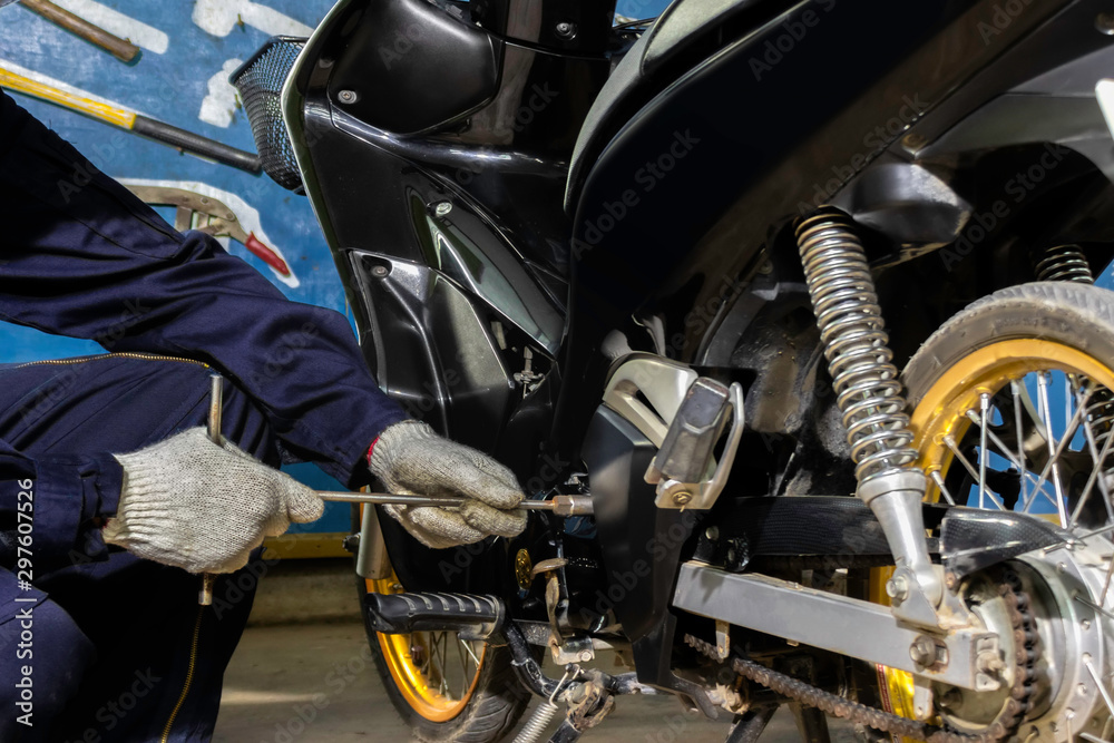 Image is Close up,People are repairing a motorcycle Use a wrench and a screwdriver to work. Image is Close up,People are repairing a motorcycle Use a wrench and a screwdriver to work.