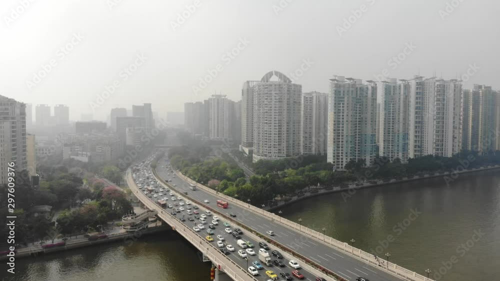 Flying a drone in a residential area along the promenade. There was a traffic jam on the bridge, a lot of car traffic. The city is in smog, poor visibility. Guangzhou, China Flying a drone in a residential area along the promenade. There was a traffic jam on the bridge, a lot of car traffic. The city is in smog, poor visibility. Guangzhou, China