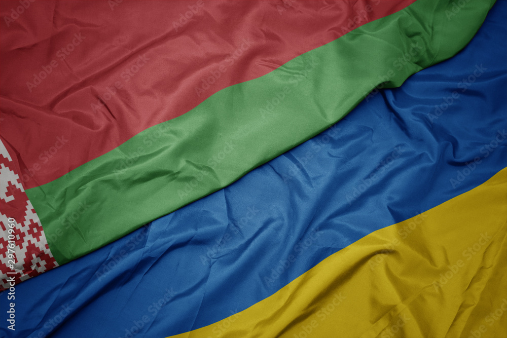 waving colorful flag of ukraine and national flag of belarus. waving colorful flag of ukraine and national flag of belarus.