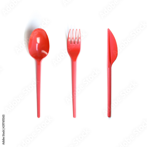 Plastic red disposable spoon, fork and knife. Close up. Isolated on white background