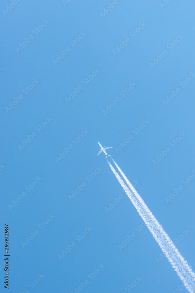 Airplane in a blue sky with clouds and condensation trails, Germany Airplane in a blue sky with clouds and condensation trails, Germany