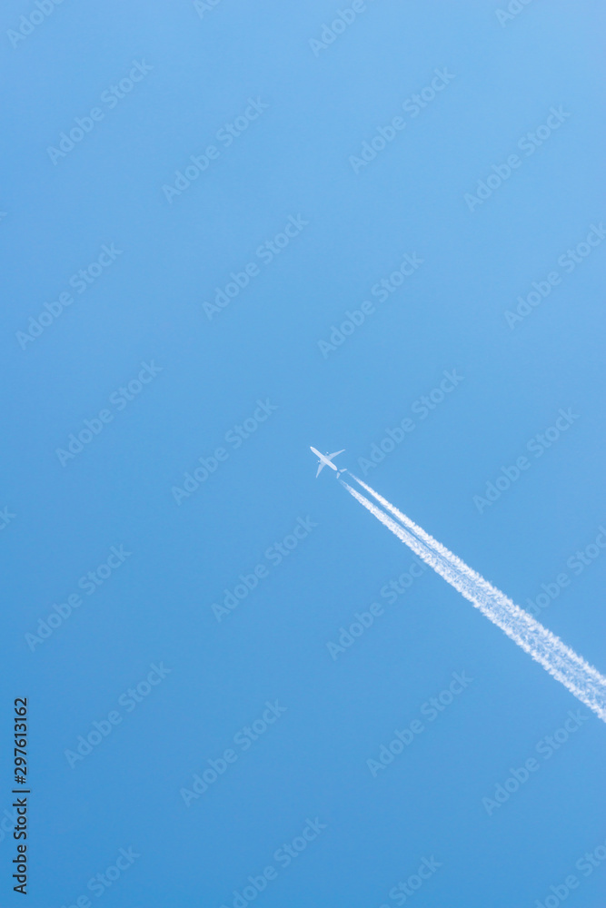 Airplane in a blue sky with clouds and condensation trails, Germany Airplane in a blue sky with clouds and condensation trails, Germany