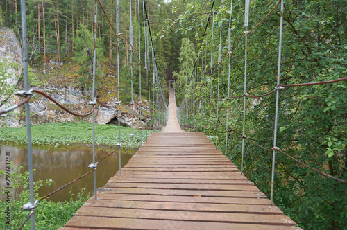 karst suspension bridge over the river Serga in the forest in cloudy cloudy weather in national Park in Sverdlovsk region cervine stream