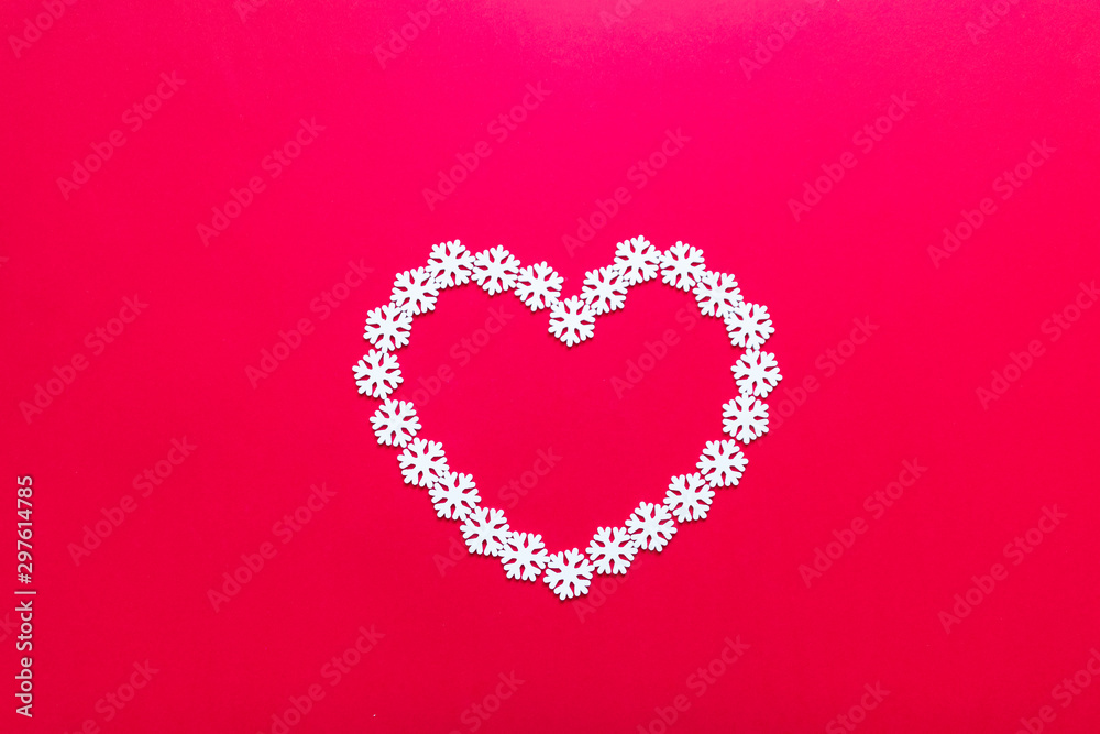 White snowflake decorations in shape of heart on red background
