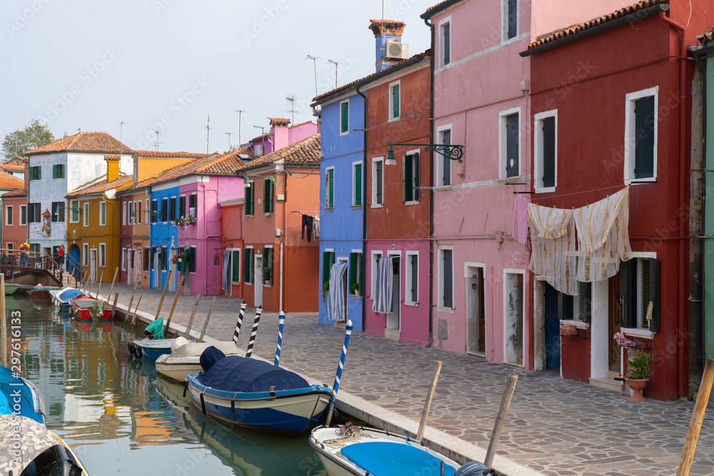 Colorful houses in Burano island. Canal view with boats. Travel photo. Venice. Italy. Europe.