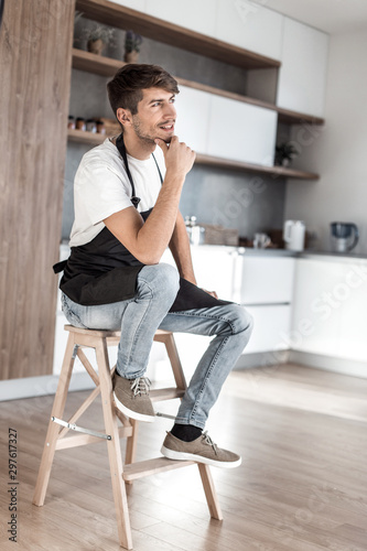 attractive man with an apple sitting in a home kitchen