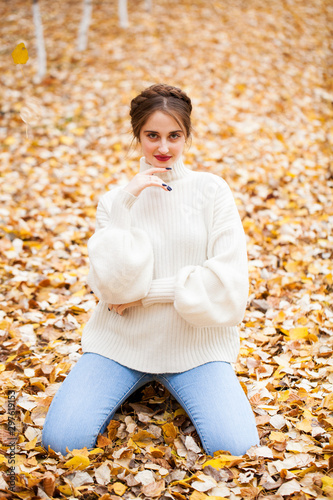 Young beautiful girl in blue jeans and gwhite sweater photo