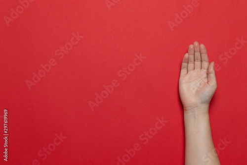 Female caucasian clean hand gesture of an open palm on red background