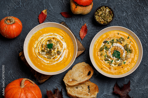 Vegetarian autumn pumpkin cream soup with seeds in white bowls. Pumpkin soup