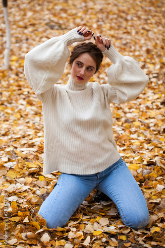 Young beautiful girl in blue jeans and gwhite sweater photo