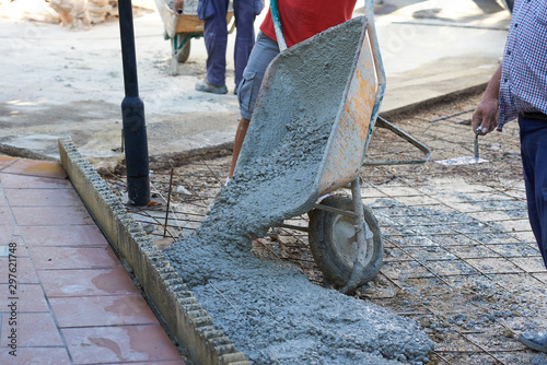  Construction workers working outdoors pouring concrete.