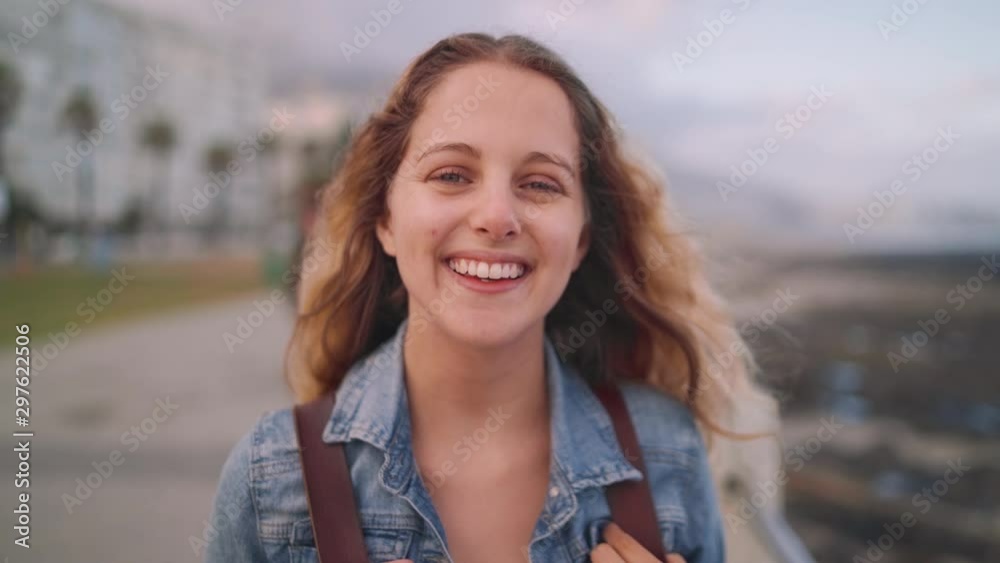 Portrait of a young attractive smiling woman on city street feel happy and look at camera Portrait of a young attractive smiling woman on city street feel happy and look at camera