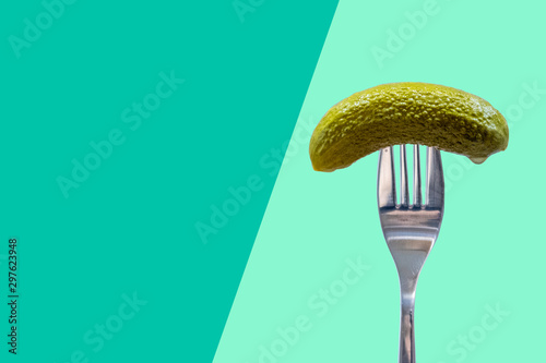 Pickle on fork, dill, gherkin, aqua and green background, national pickle day	