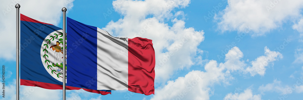 Belize and Reunion flag waving in the wind against white cloudy blue sky together. Diplomacy concept, international relations. Belize and Reunion flag waving in the wind against white cloudy blue sky together. Diplomacy concept, international relations.