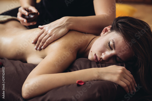 The massage therapist's hand spreads the body essential oil