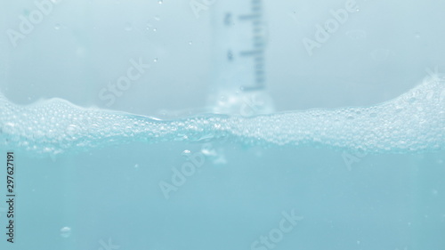 Water and bubbles with a syringe dip in blue water