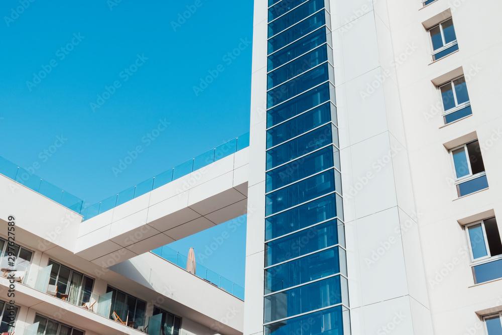 Fachada de hotel con ventanales en contrapicado con cielo azul