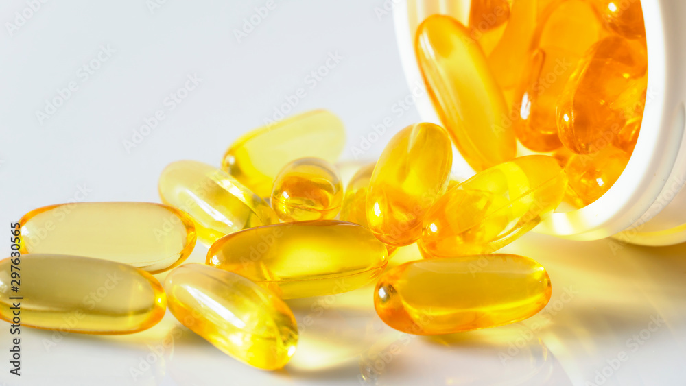Fish oil capsules with omega 3 and vitamin D in white bottle on isolated on white background,varies benefits supplement and support heart health,healthy diet concept, selective focus Fish oil capsules with omega 3 and vitamin D in white bottle on isolated on white background,varies benefits supplement and support heart health,healthy diet concept, selective focus