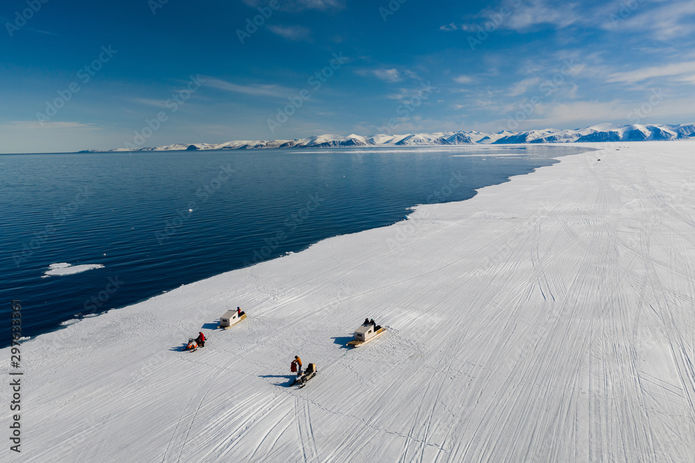 Aerial drone photo of tourists visit the floe edge near Sirmilik National Park in Nunavut, Canadaa