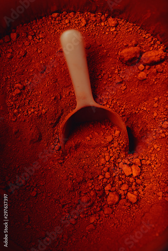 Canvas Print crimson pigment powder with spoon
