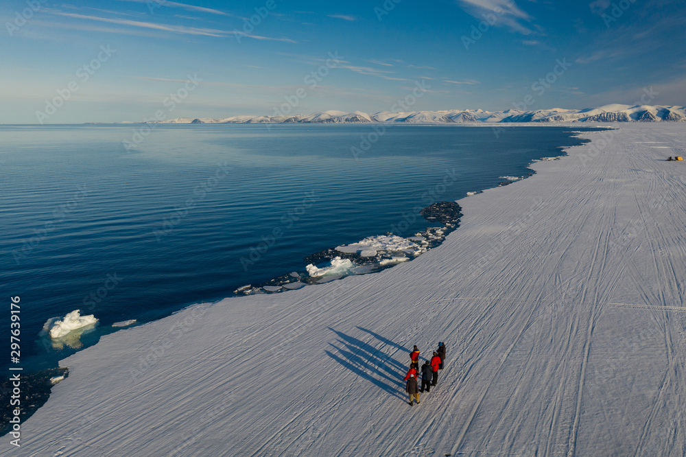 Aerial drone photo of tourists visit the floe edge near Sirmilik National Park in Nunavut, Canadaa