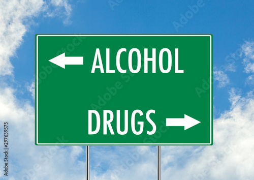 Alcohol vs drugs green road sign over blue sky background. Concept road sign collection.