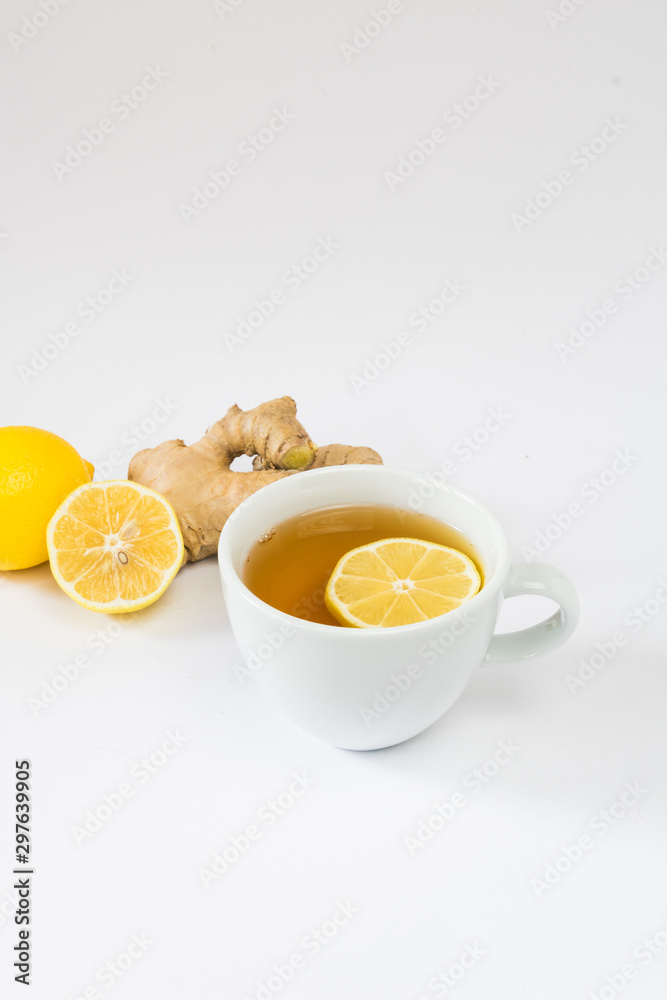 Cup of tea with lemon and ginger on a white background. The concept of tea from colds and to improve immunity. Detox drink components Cup of tea with lemon and ginger on a white background. The concept of tea from colds and to improve immunity. Detox drink components