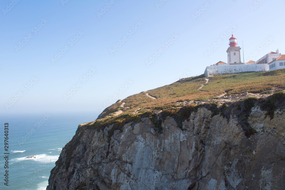 Beautiful view of the beach, lighthouse  and ocean on the sunny day. Cape Roca. Portugal.