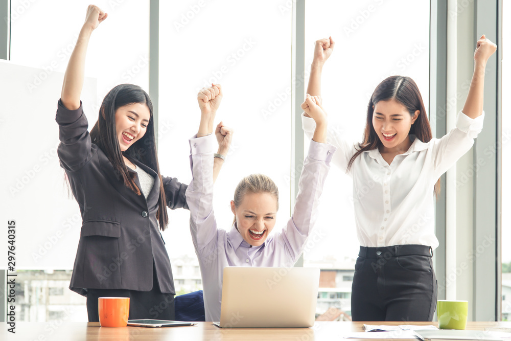 Three businesswomen putting their hands up and cheering with joy. Business and teamwork concept. Three businesswomen putting their hands up and cheering with joy. Business and teamwork concept.