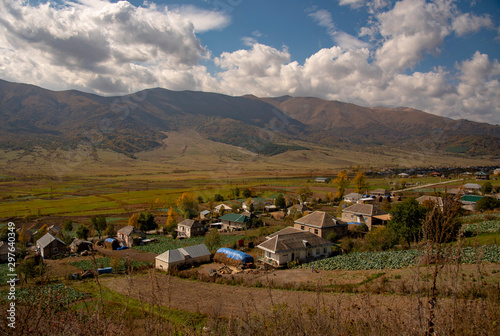 View of the village at the foot of mountains over blue cloudy sky. photo