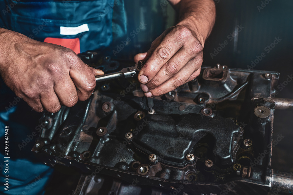 The auto mechanic deconstructs the internal combustion engine. Repair service. The auto mechanic deconstructs the internal combustion engine. Repair service.