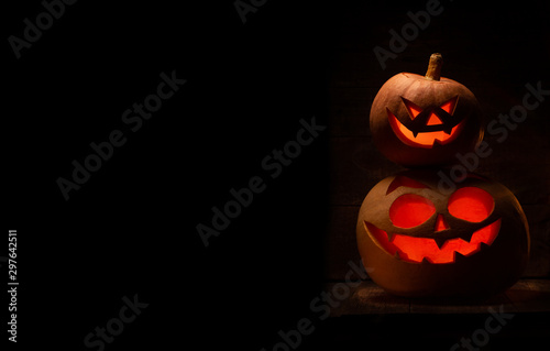 Two Halloween pumpkin with scary face. Jack-o-lantern in the dark photo