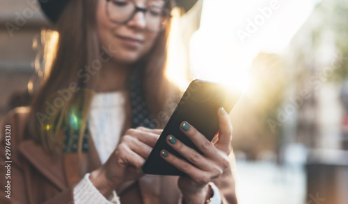 Woman holding in hands mobile phone. Girl traveler in hat using gadget cellphone in europe sunlight city. Digital internet lifestyle mockup. Close up technology smartphone online communication