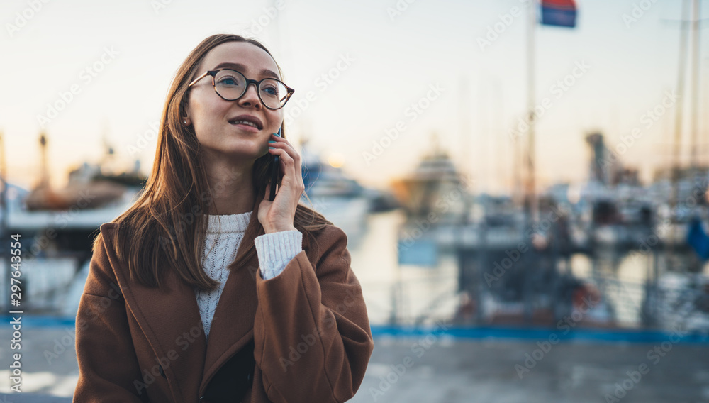 Traveler woman with suitcase calling mobile phone in evening port Barcelona. Girl tourist in glasses using smartphone technology online gadget cellphone. Digital internet lifestyle mockup