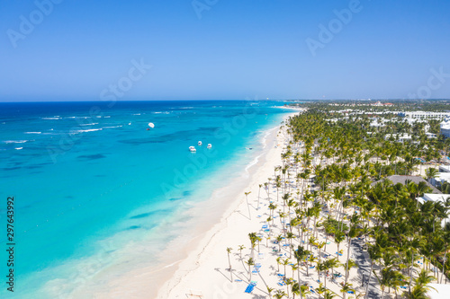 Obraz na płótnie Aerial view from drone on tropical coastline with coconut palm trees, sunbeds an