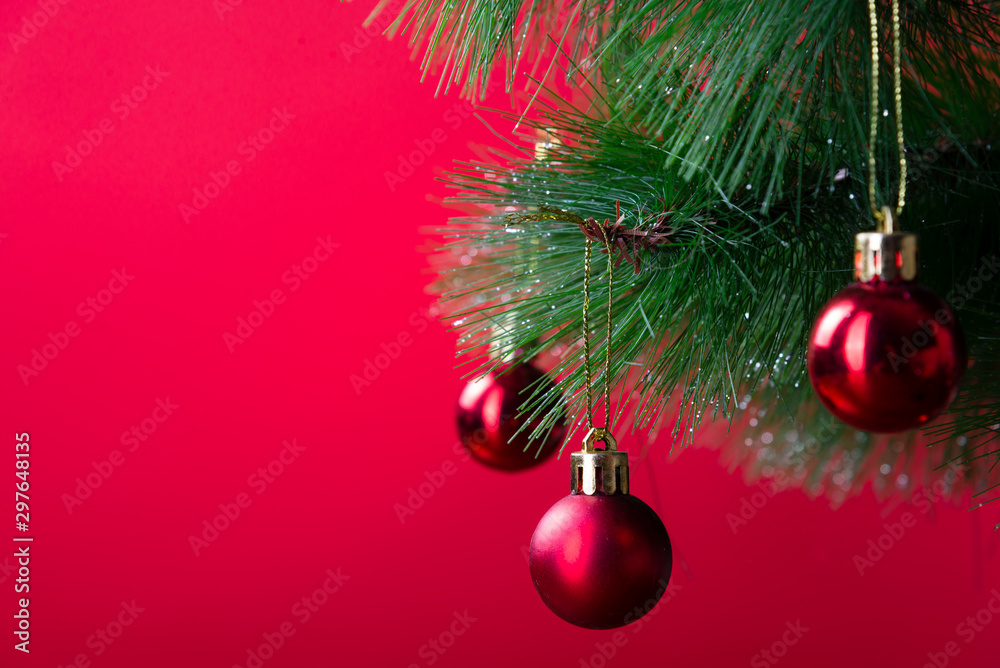 Christmas pine branch with red balls close-up on a red background Christmas pine branch with red balls close-up on a red background